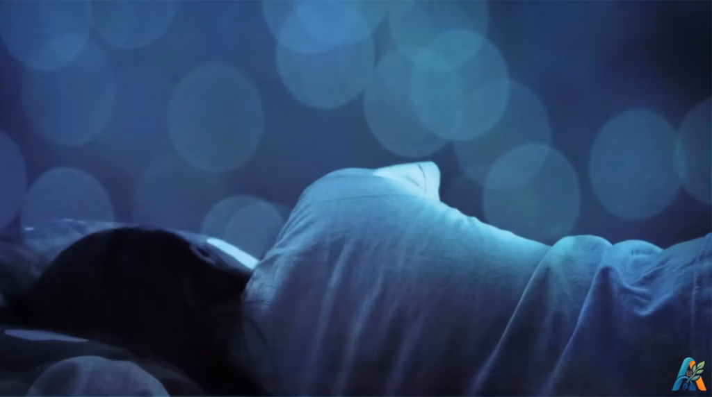 Seseorang tertidur pulas membelakangi kamera di bawah selimut dengan latar belakang bokeh biru, ilustrasi saat sepi dalam lelap