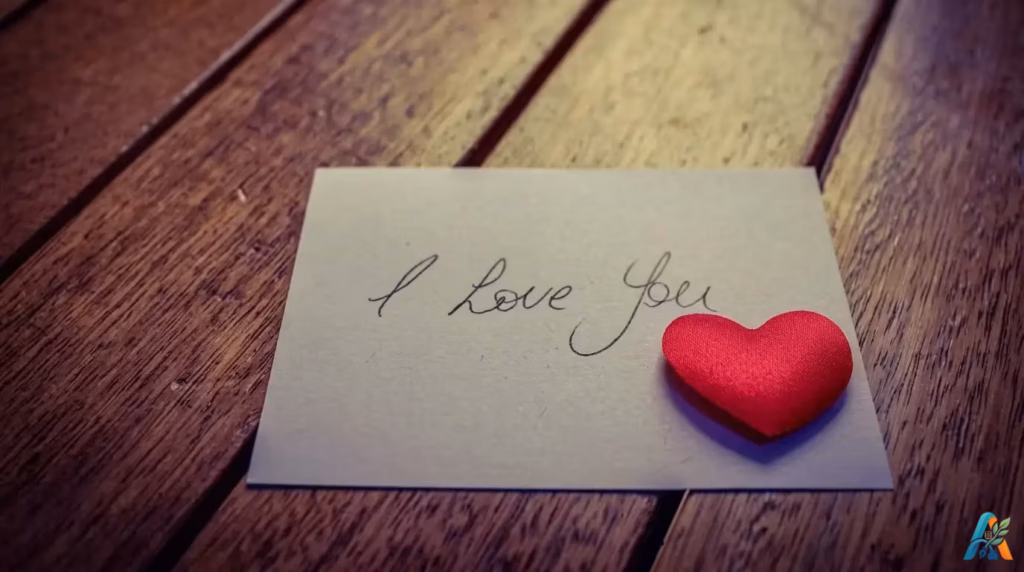 Kartu ucapan dengan tulisan tangan I Love You dan hiasan hati merah di atas meja kayu untuk artikel surat cinta seorang pengusaha