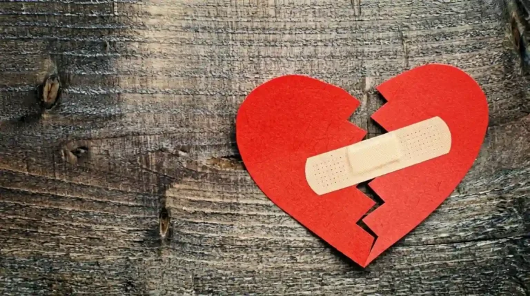 Hati kertas merah yang terbelah dan ditempel plester di atas permukaan kayu, simbol penyembuhan untuk cara-mengobati-patah-hati-dalam-7-hari.webp.