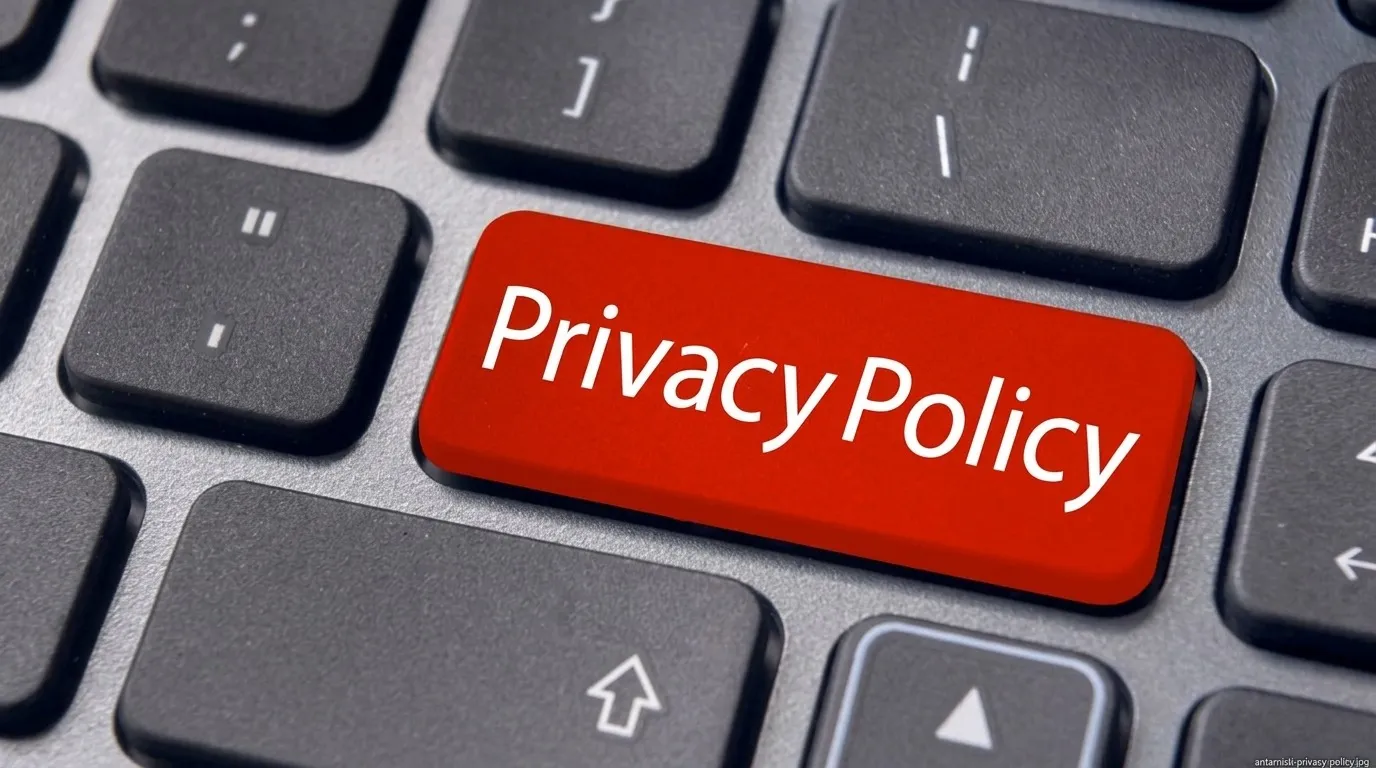 Sebuah close-up keyboard laptop hitam, menampilkan tombol 'Privacy Policy' berwarna merah cerah di tengah sebagai titik fokus yang menonjol.