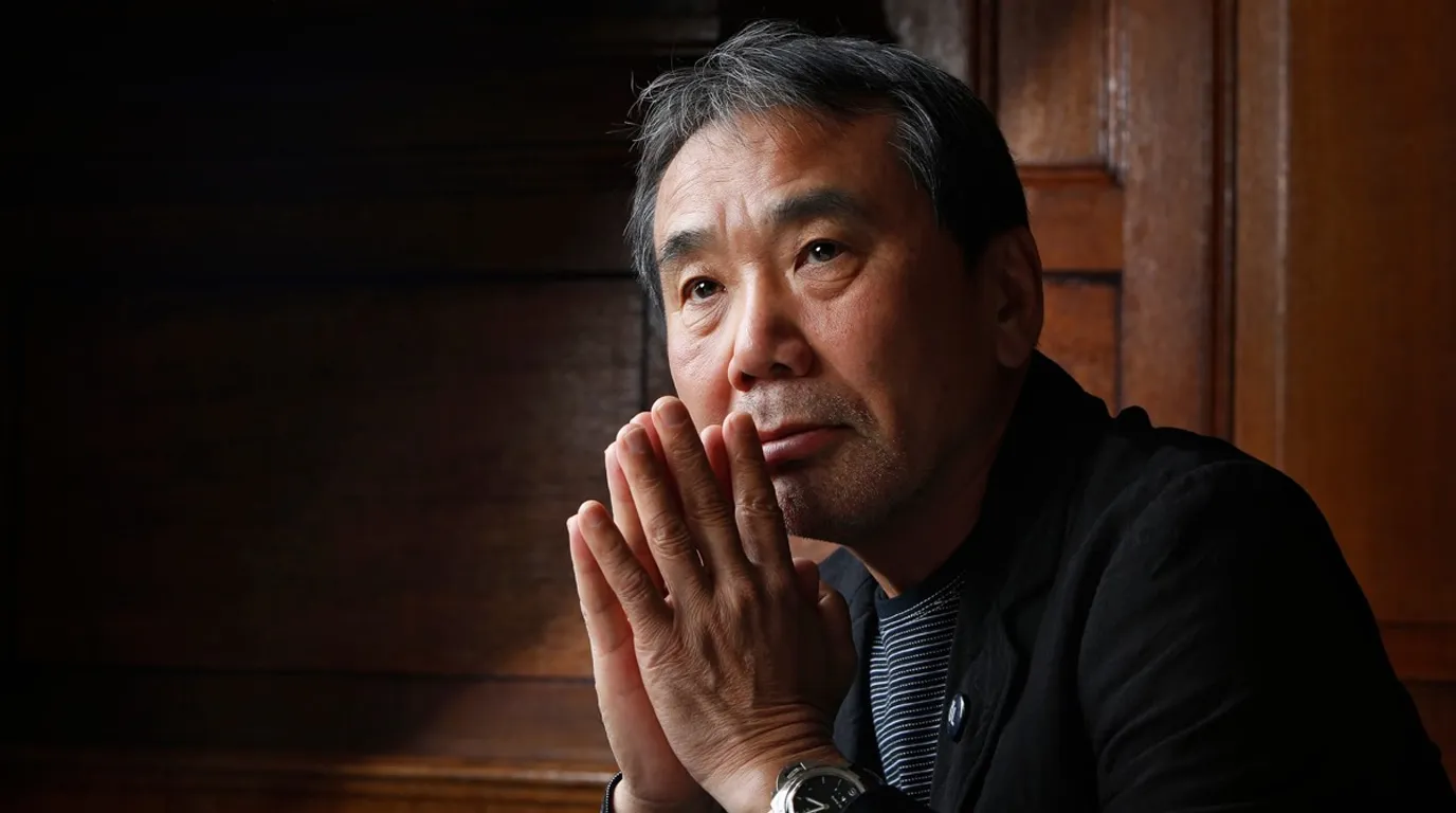 Potret dekat Haruki Murakami berpose menangkupkan kedua tangan di depan wajah