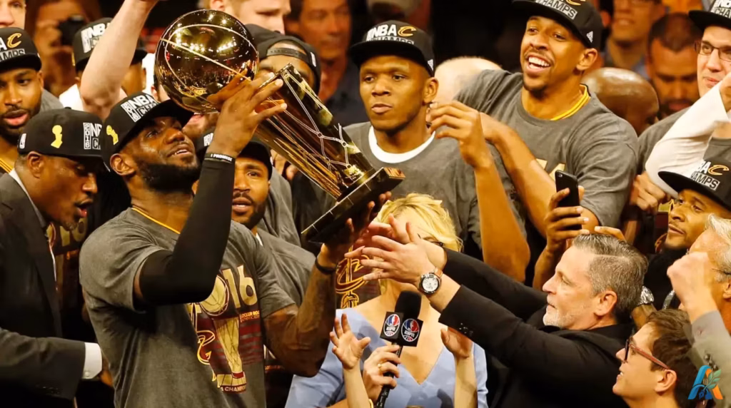 LeBron James mengangkat trofi juara NBA 2016 bersama rekan setimnya di Cleveland Cavaliers dalam perayaan kemenangan