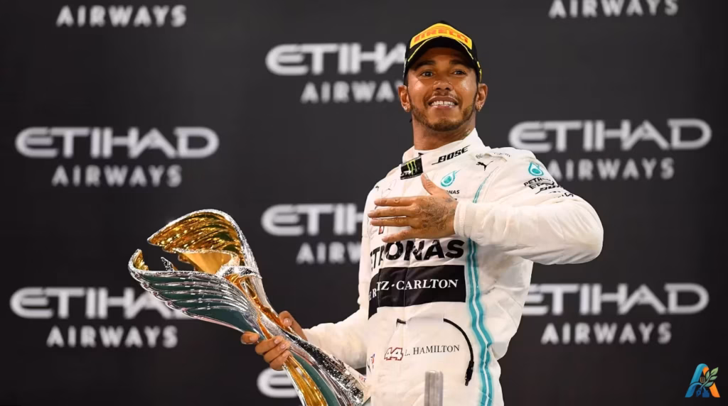 Lewis Hamilton tersenyum memegang trofi juara F1 dengan latar belakang logo Etihad Airways