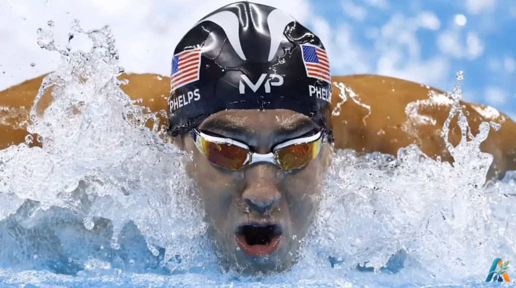 Michael Phelps berenang gaya kupu-kupu dengan intens dengan topi renang berbendera Amerika Serikat