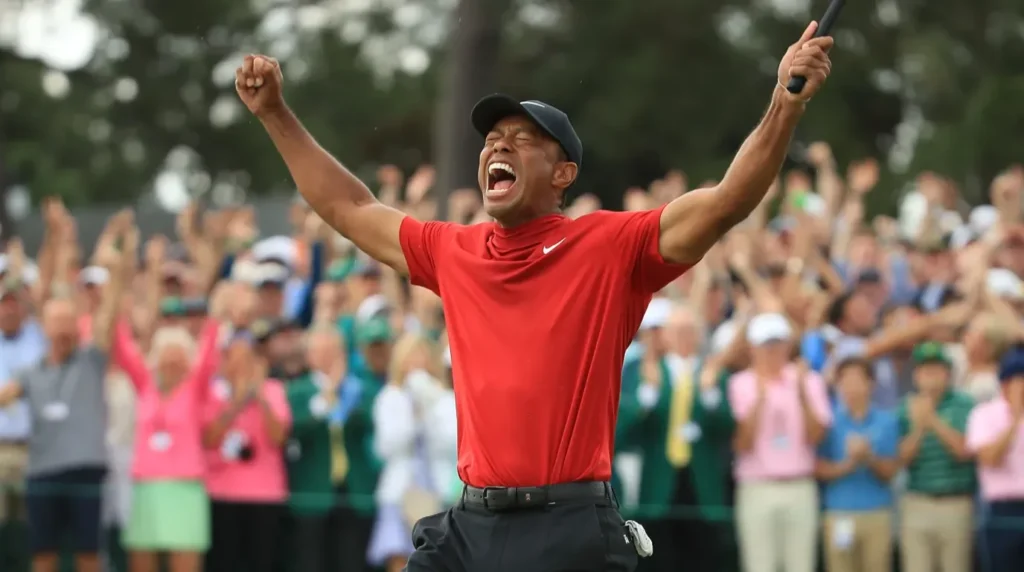Tiger Woods merayakan kemenangan turnamen golf dengan penuh semangat sambil mengangkat tangan di hadapan penonton