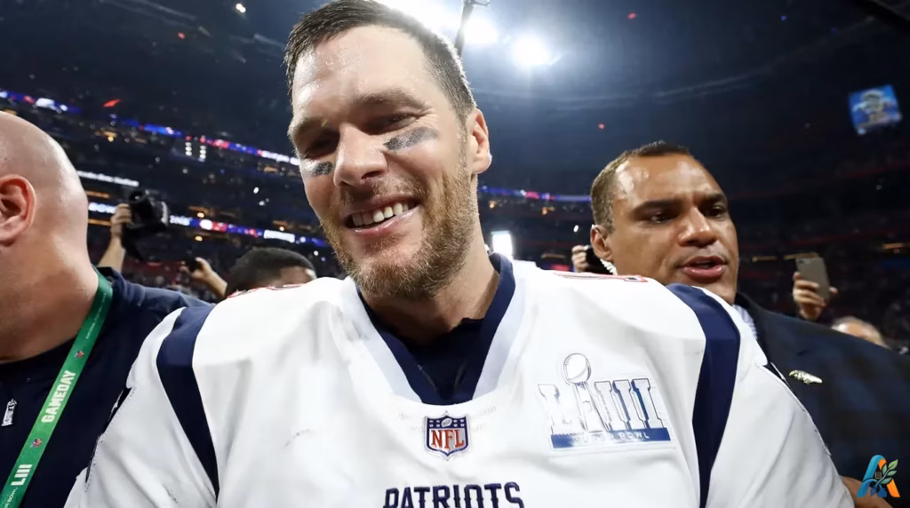 Tom Brady tersenyum gembira setelah memenangkan Super Bowl mengenakan jersey New England Patriots