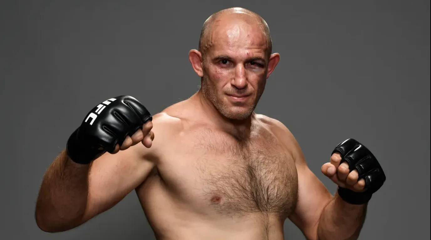 Aleksei Oleinik, petarung MMA kelas berat UFC, berpose dalam posisi bertarung dengan sarung tangan hitam