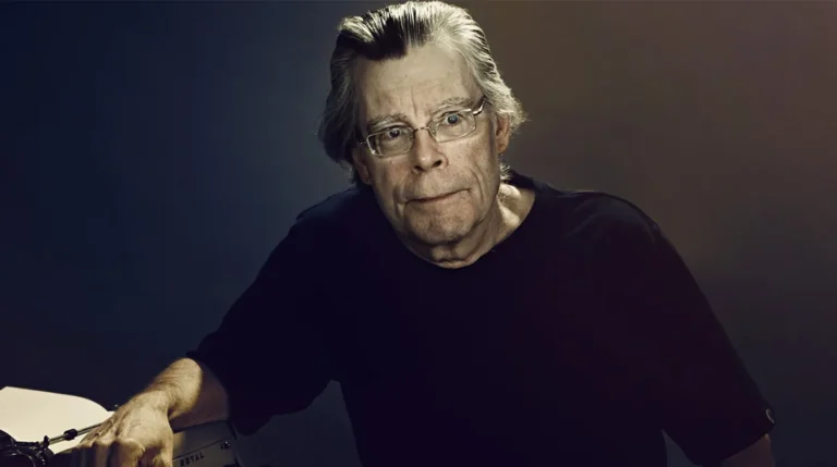 Foto profil Stephen King dengan ekspresi wajah serius dan tangan bersandar pada mesin tik jadul