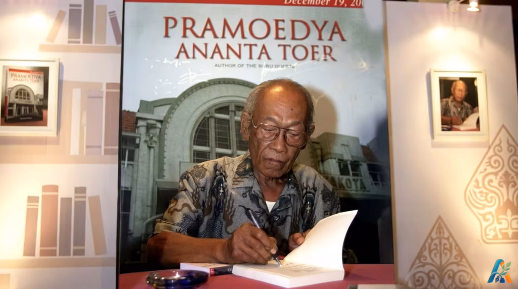Pramoedya Ananta Toer sedang menandatangani buku dalam sebuah acara peluncuran.