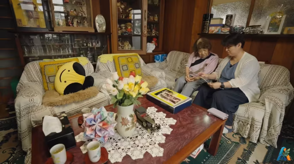 Saori Hayasaki penyintas generasi ketiga bersama nenek neneknya, Yoshimura, melihat dokumentasi sejarah bom atom di ruang tamu.