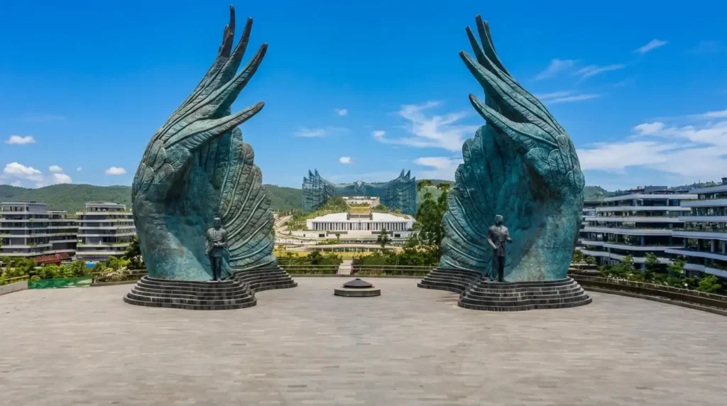Pemandangan Istana Garuda di Ibu Kota Nusantara (IKN), Kalimantan Timur, dengan patung sayap Garuda raksasa dan gedung modern di bawah langit biru.